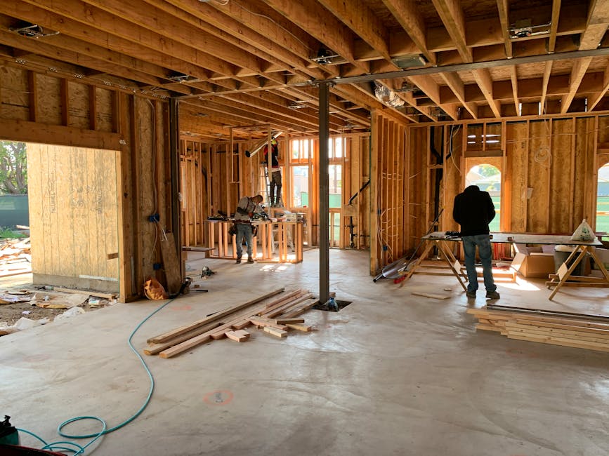 Workers constructing a house framework, showcasing interior carpentry and building process.