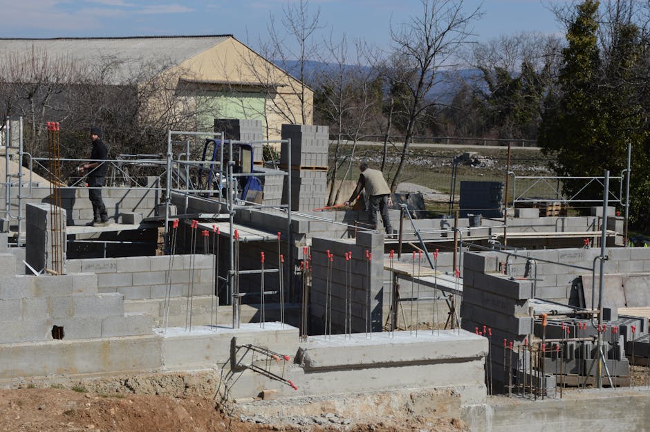 Construction workers building a concrete structure at a sunlit site