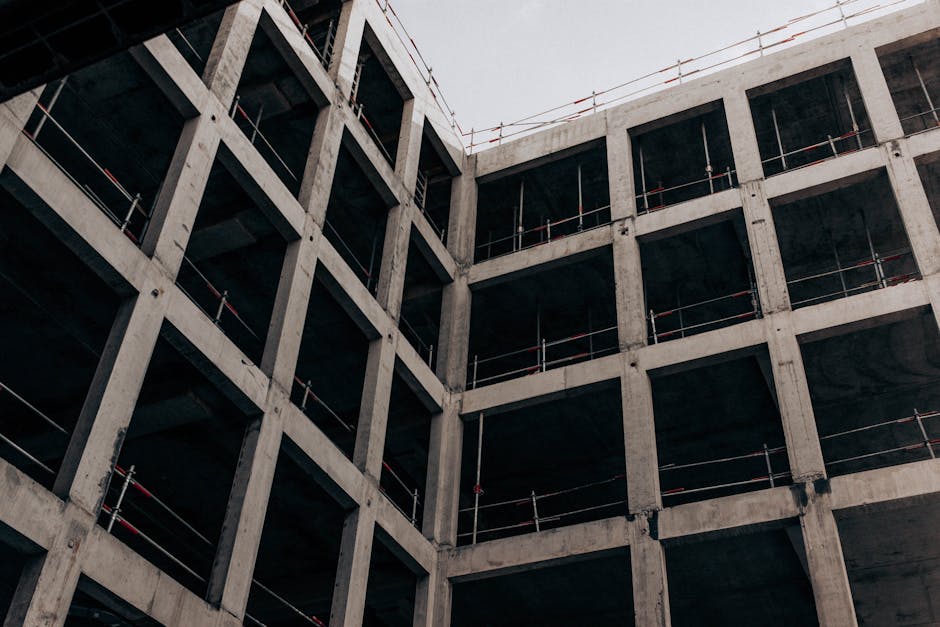 A low angle view of a modern concrete building under construction, showcasing its structure and design.